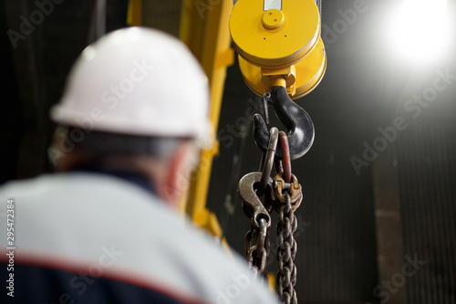 Yellow overhead-traveling crane with hard hat worker operator