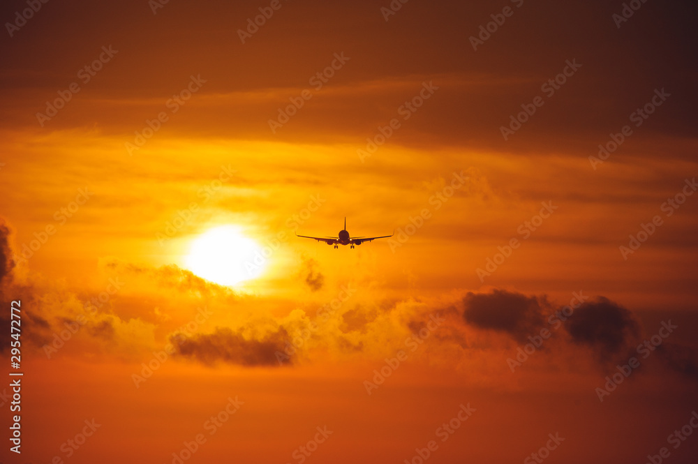 Silhouette of a passenger airliner in the sky during sunset. Airplane in the sky.