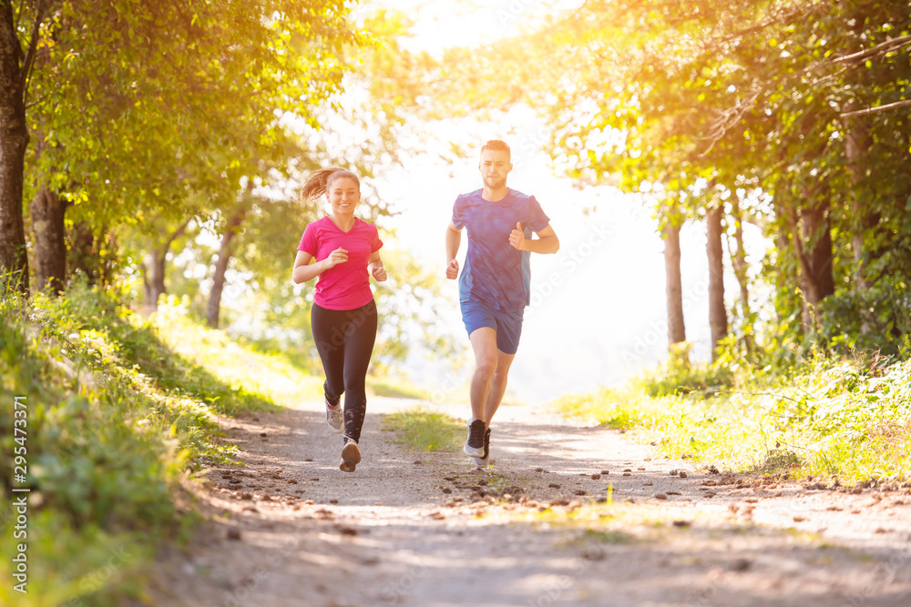 Obraz premium young couple jogging on sunny day at nature