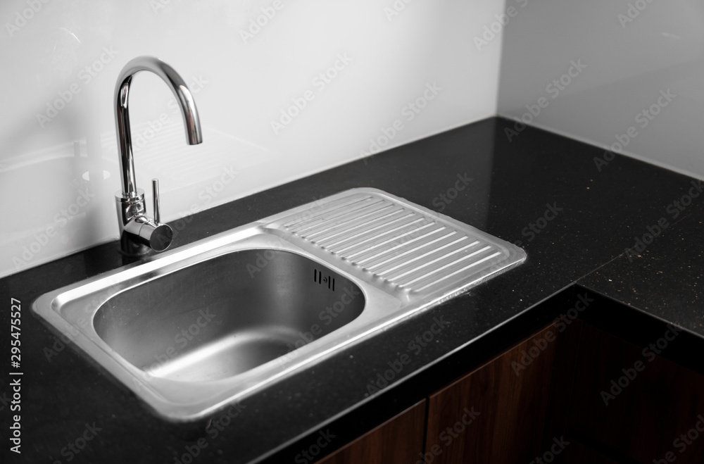 Close up on modern kitchen metal faucet and metal kitchen sink. Close up on modern kitchen metal faucet and metal kitchen sink.