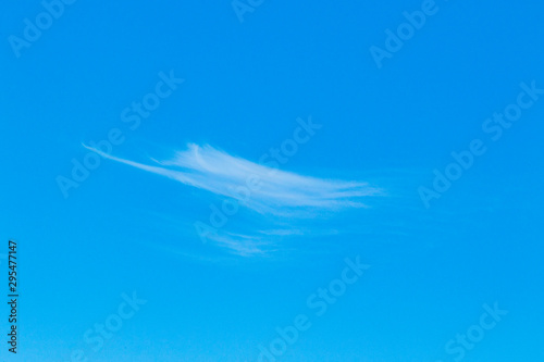 Cirrus clouds in the blue sky. Sunny day, calm weather