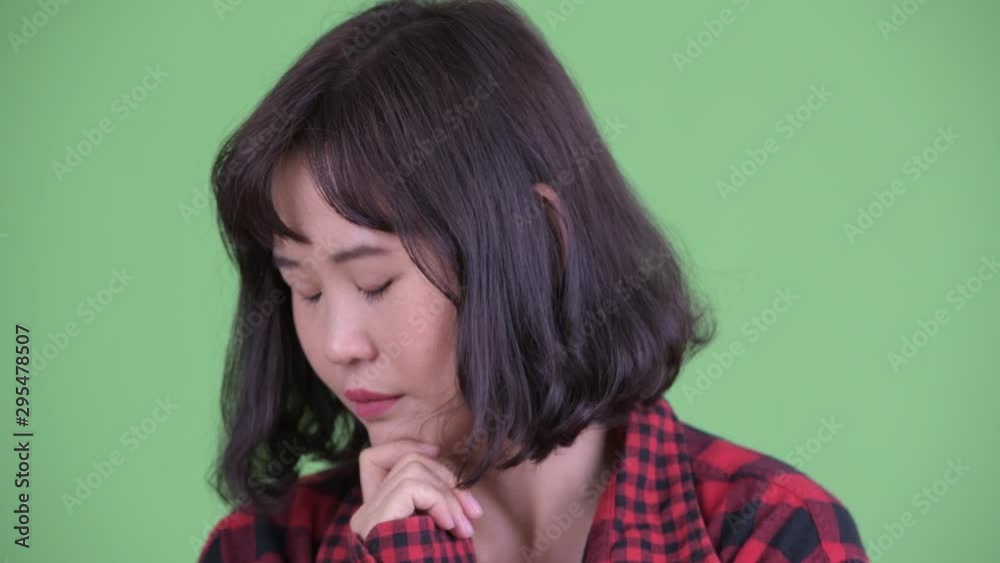 Face of stressed Asian hipster woman thinking and looking down Face of stressed Asian hipster woman thinking and looking down