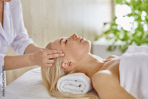 Beautiful woman with closed eyes getting a massage in the spa s