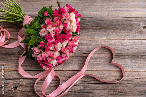 A bouquet of roses on a wooden background.