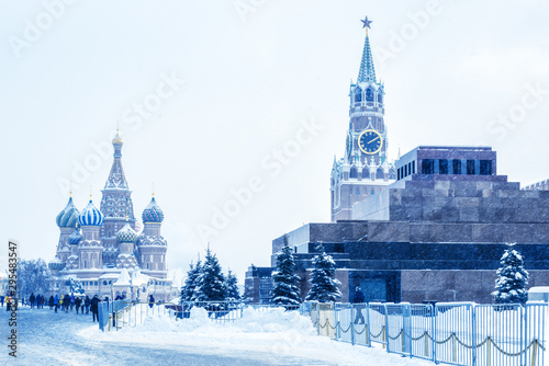 Moscow Red Square in winter, Russia. This place is a famous tourist attraction of Moscow. Cold winter view of St Basil Cathedral and Moscow Kremlin. Panorama of Moscow city center during snowfall.
