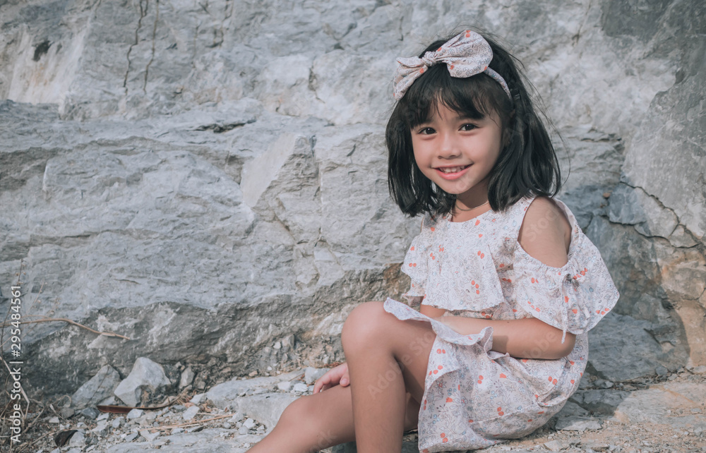 child little girl sitting near the mountain child little girl sitting near the mountain