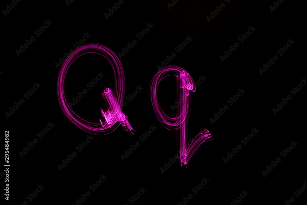 Long exposure photograph of  the letter q in pink neon color, in upper case and lower case, parallel lines pattern against a black background. Light painting photography.