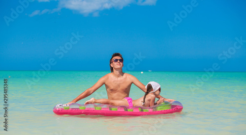 Little girl with young father on an air mattress in the sea photo