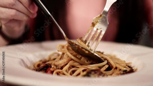 Woman Using Fork and Spoon to Eating Spaghetti Beef Sauce in Restaurant. Selective Focus. Closeup Shot. SLow Motion