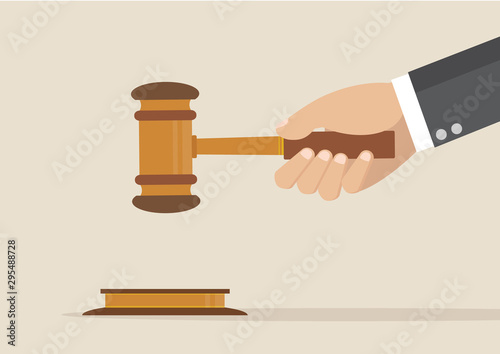 Hand holding judges gavel.