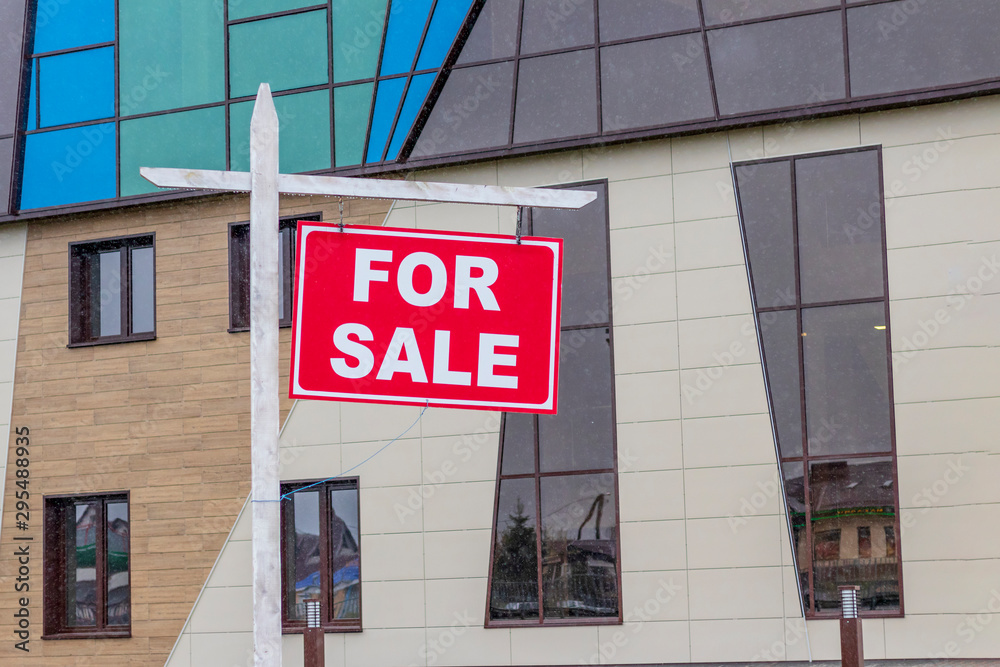 Naklejka premium daylight. hanging sign on it the inscription is on sale. in the background real estate.