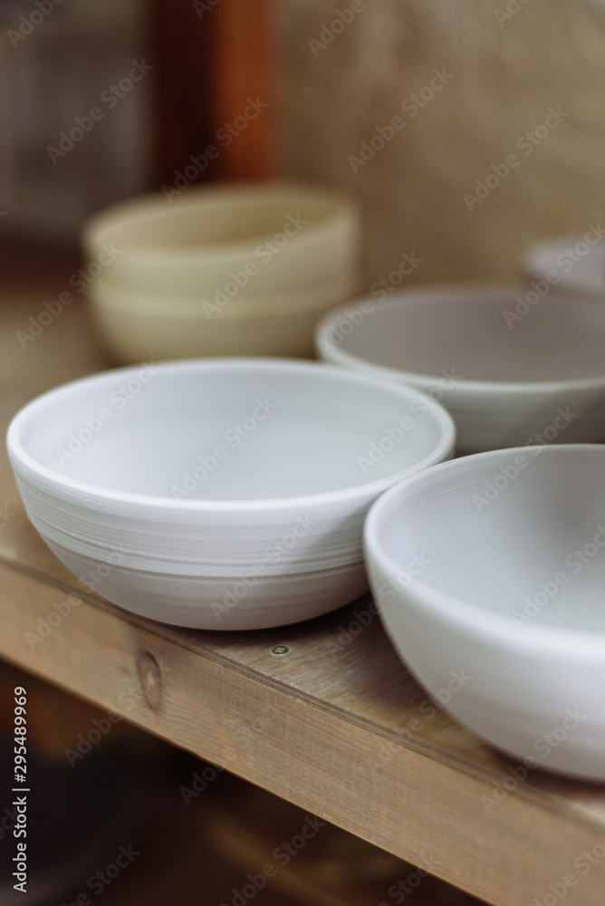 Gray handmade ceramic plates. Glazed clay plates in a pottery workshop. Gray handmade ceramic plates. Glazed clay plates in a pottery workshop.