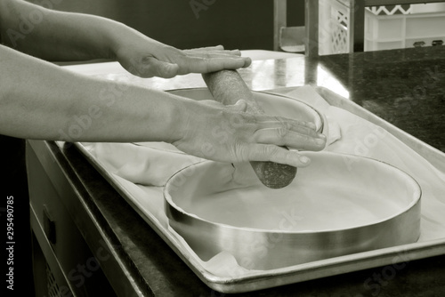 Closeup of hands preparing form to make pie photo