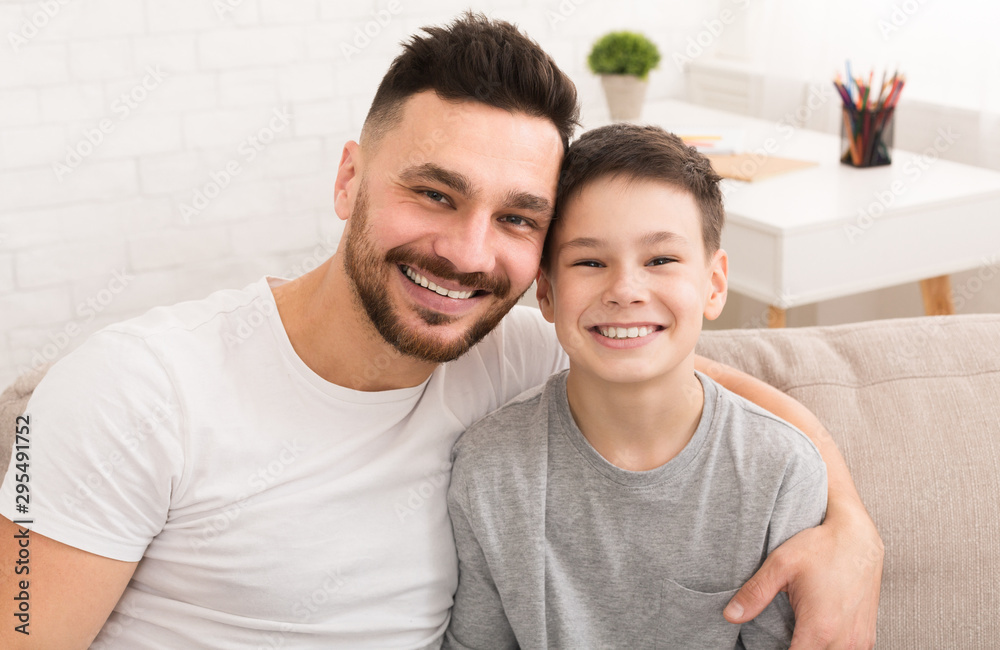 Portrait of cheerful dad and son, embracing at home Portrait of cheerful dad and son, embracing at home