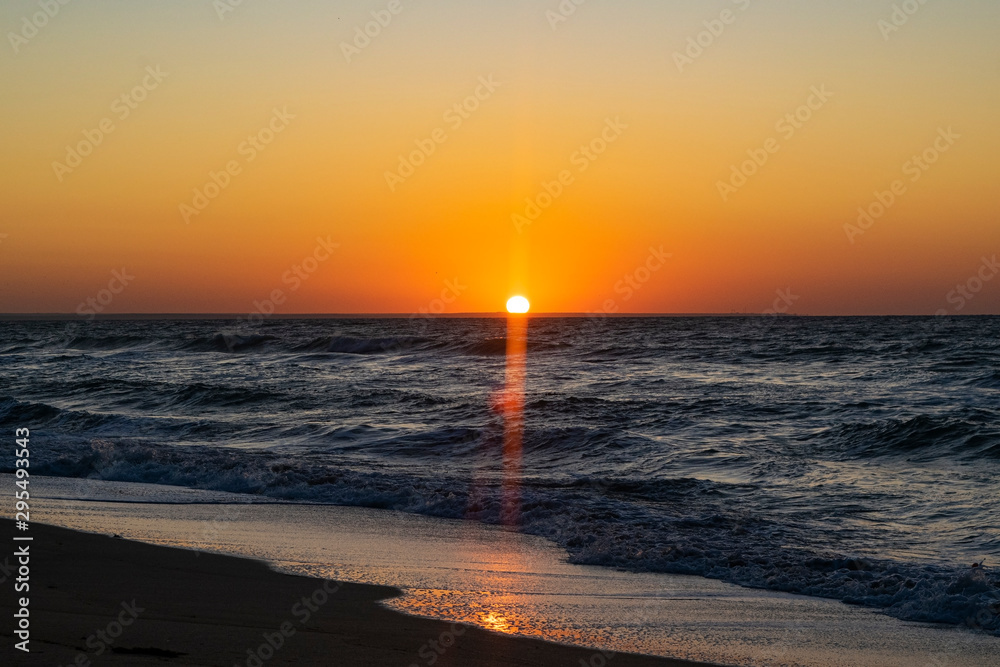 Fototapeta premium Sunrise over the Black sea, waves on the sandy beach.