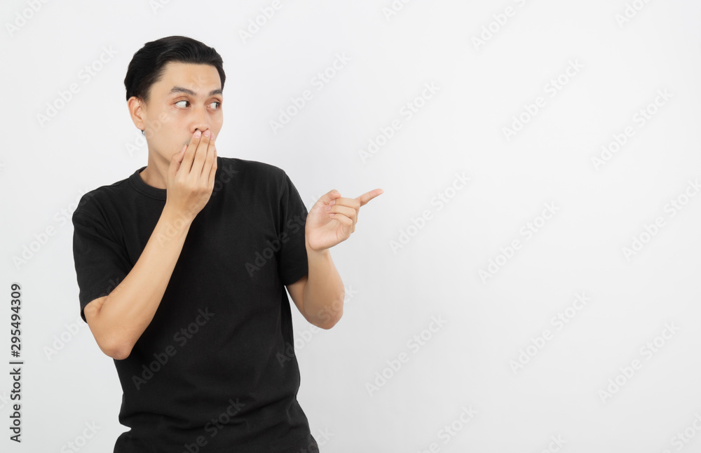Young asian man with black shirt pointing to the side with a finger to present a product or an idea while looking forward surprising isolated on white background. Young asian man with black shirt pointing to the side with a finger to present a product or an idea while looking forward surprising isolated on white background.
