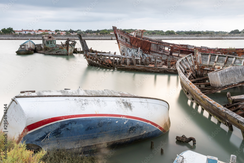 The Noirmoutier boats cemetery early in the morning. A group of wrecks of old wooden fishing boats at high tide