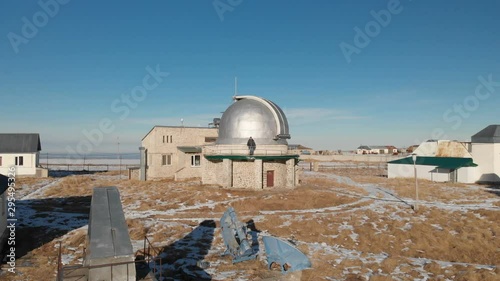 Wallpaper Mural An adult male observatory worker stands on the observation deck of the observation dome and looks into the distance. Aerial view against a clear blue sky. Astronomy science concept Torontodigital.ca