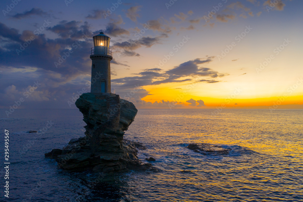The beautiful Lighthouse Tourlitis of Chora in Andros island and a seagull, Cyclades, Greece