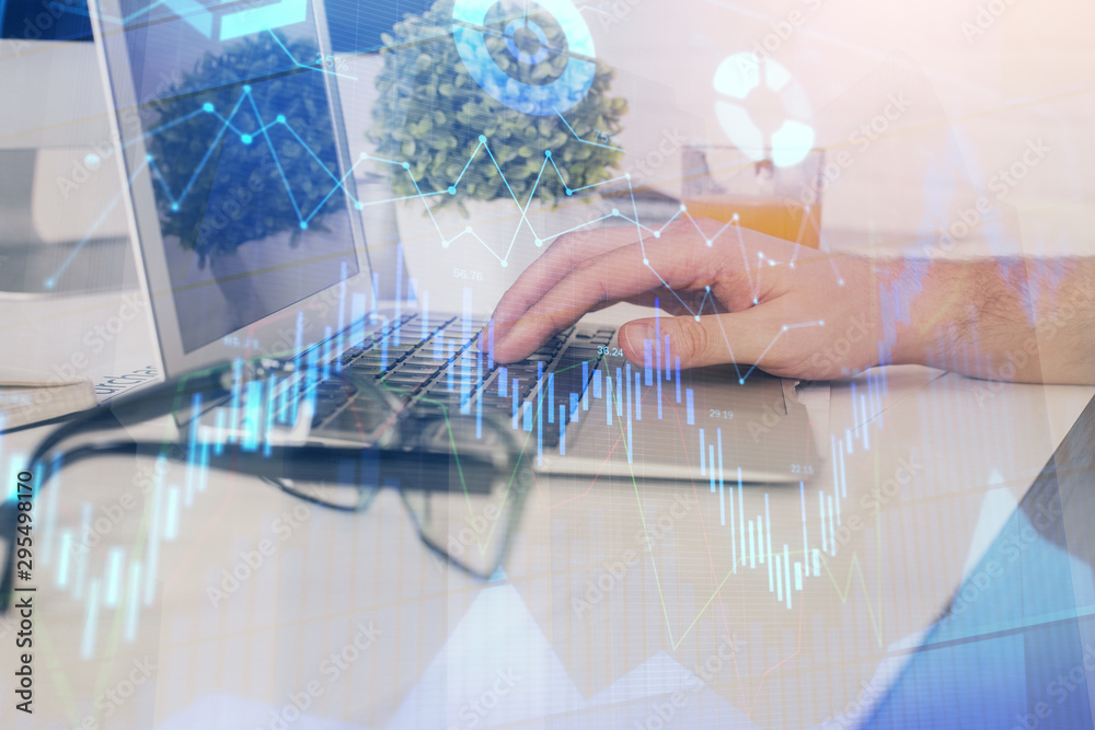 Multi exposure of graph with man typing on computer in office on background. Concept of hard work. Closeup.