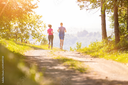 young couple jogging on sunny day at nature