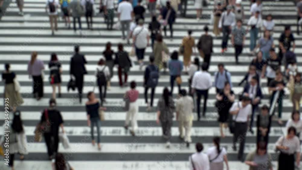 UMEDA, OSAKA, JAPAN - CIRCA SEPTEMBER 2019 : Aerial blurred high angle view of zebra crossing near Osaka train station. Crowd of people at the street. Shot in busy rush hour. Wide slow motion. UMEDA, OSAKA, JAPAN - CIRCA SEPTEMBER 2019 : Aerial blurred high angle view of zebra crossing near Osaka train station. Crowd of people at the street. Shot in busy rush hour. Wide slow motion.