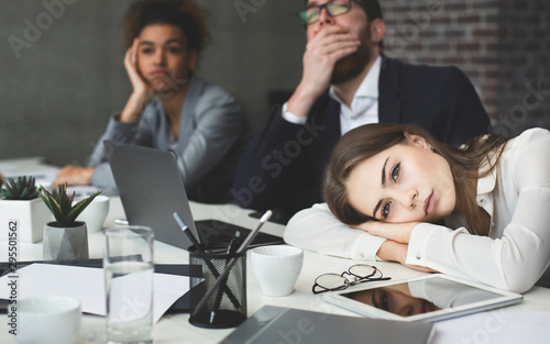 Boring presentation. Young business people looking bored photo