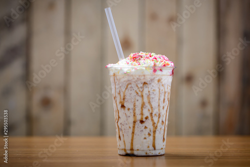 Delicious milkshake  in clear plastic cup with a straw and copy space