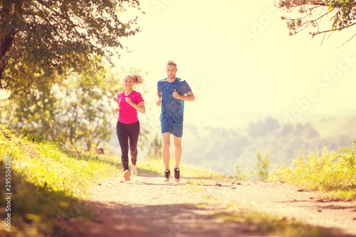 young couple jogging on sunny day at nature