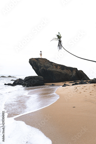 Woman in the top of a rock in the beach (Asia)