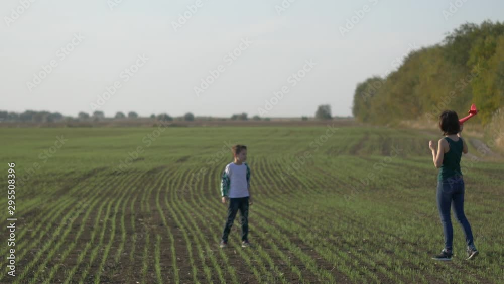 Mom and son launch a plane in the field Mom and son launch a plane in the field