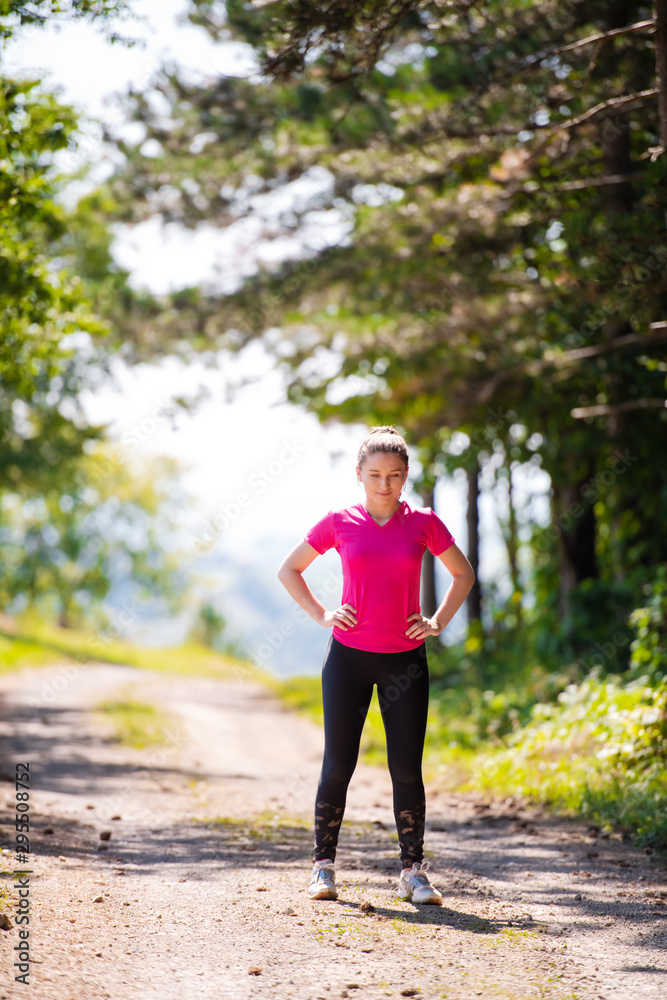 portrait of young woman jogging on sunny day at nature