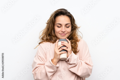 Young blonde woman holding coffee to take away
