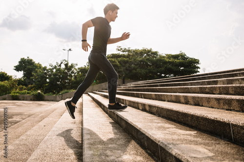 Young sport man running upstairs on city stairs