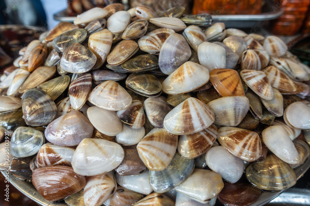 Chon Buri, Thailand - March 16, 2019: Nong Mon market. Closeup of large pile of multi-color fresh sea clams on display at booth.