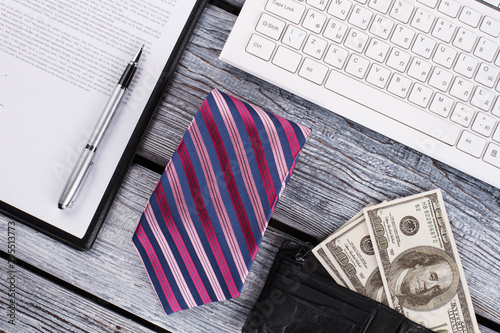 Leather purse with money, striped tie. Men's business layout. Office items. photo