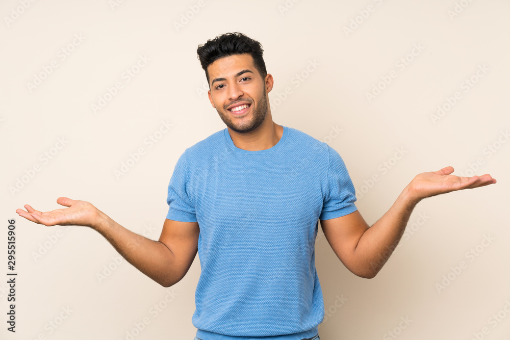 Young handsome man over isolated background holding copyspace with two hands Young handsome man over isolated background holding copyspace with two hands