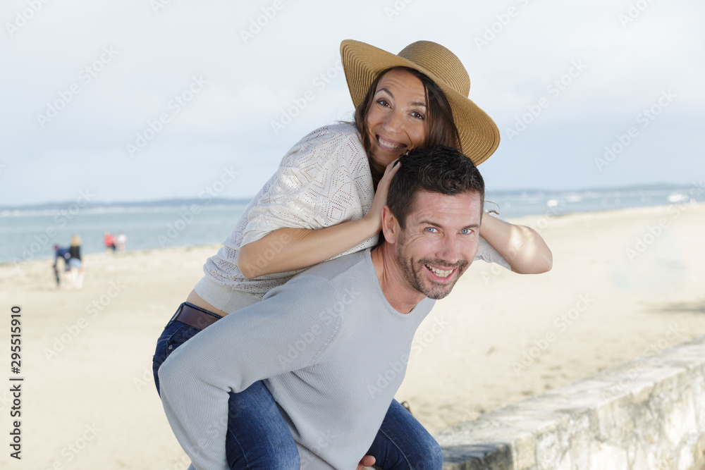 piggyback couple on the shore