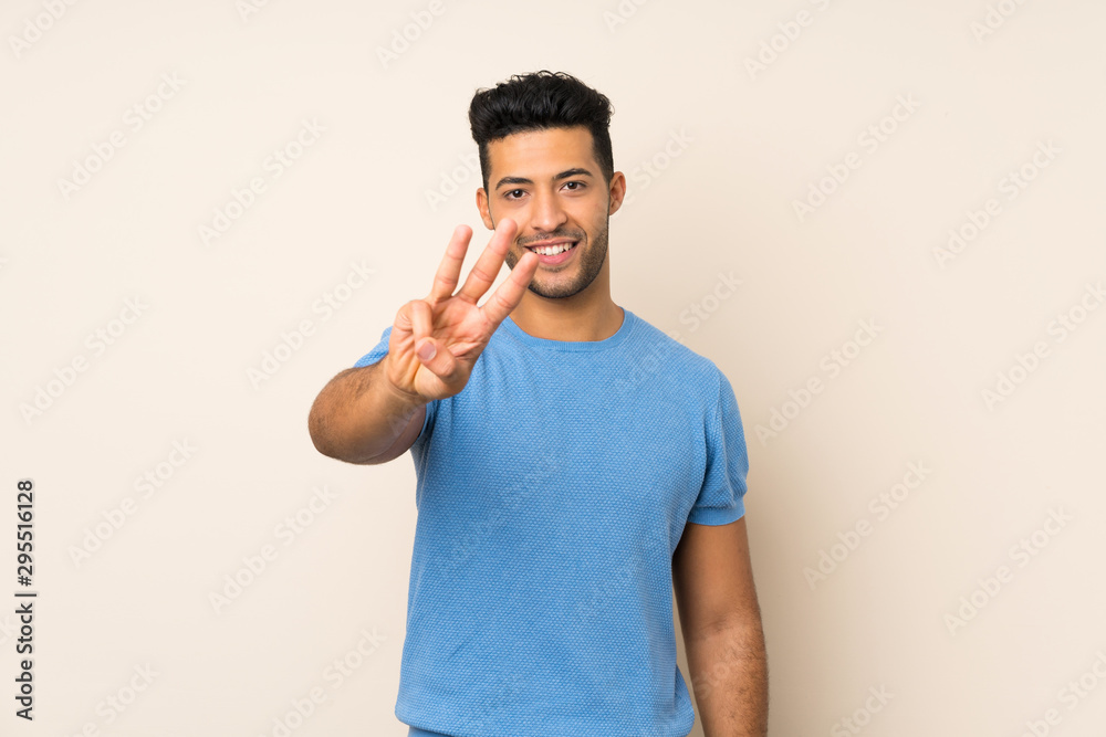 Young handsome man over isolated background happy and counting three with fingers Young handsome man over isolated background happy and counting three with fingers