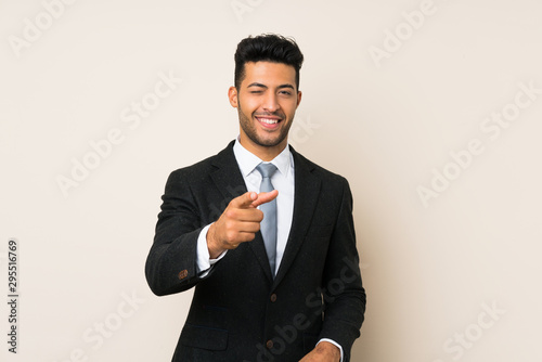Young handsome businessman man over isolated background points finger at you