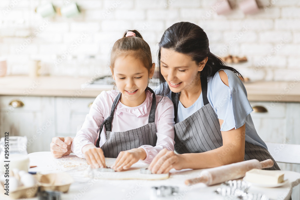 Mom and child cutting out different cookie shapes of dough Mom and child cutting out different cookie shapes of dough