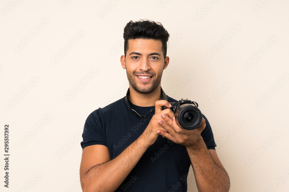Young handsome man over isolated background with a professional camera Young handsome man over isolated background with a professional camera