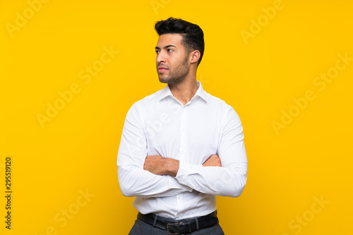 Young handsome man over isolated yellow background looking side