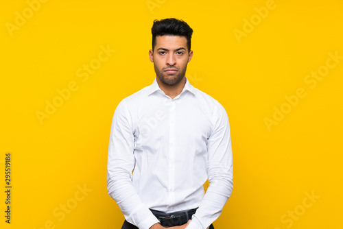 Young handsome man over isolated yellow background sad