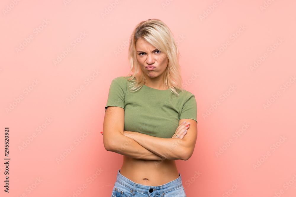Young blonde woman over isolated pink background feeling upset Young blonde woman over isolated pink background feeling upset