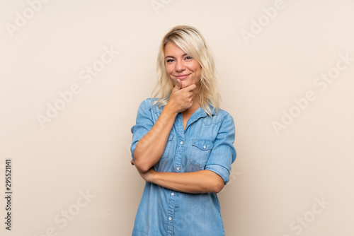 Young blonde woman over isolated background laughing