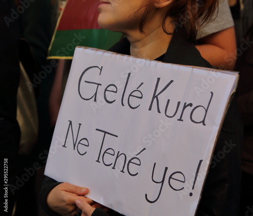 Young girl holds board with slogan in Kurdish language during street demonstration against Turkish invasion in northern Syria photo