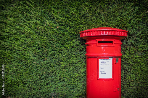 Classic Red British Pillar Box Against Hedge photo