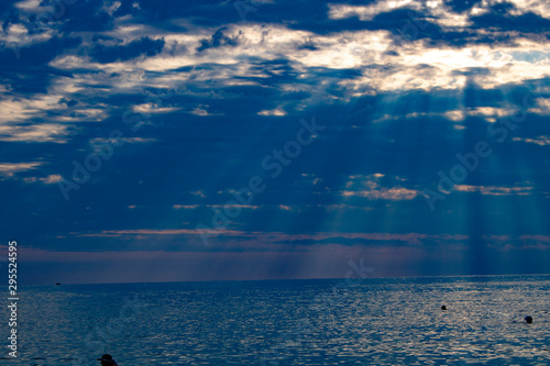The rays of the summer sun make their way through the thick clouds over the Black Sea in the evening