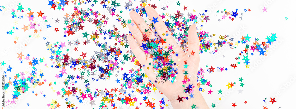 Woman hand with festive color star confetti Woman hand with festive color star confetti